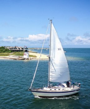 A sea vessel passing Brant Point Lighthouse on its way into the Boat Basin.